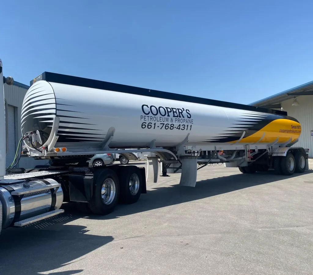 Custom vehicle wrap showcasing Cooper's Petroleum & Propane branding, featuring a sleek design with contact information, parked in a well-lit outdoor setting.