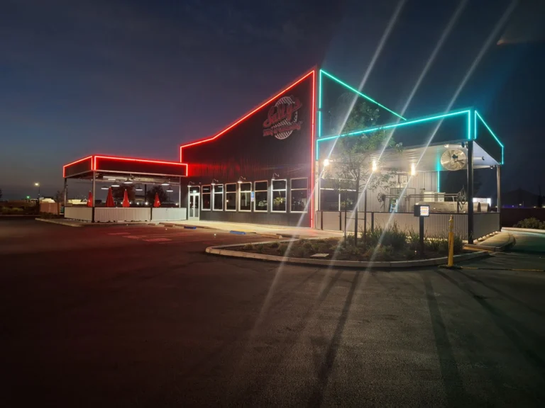 Salty's BBQ & Catering in Bakersfield, CA at night with red and teal LED accent lighting and an illuminated channel letter sign